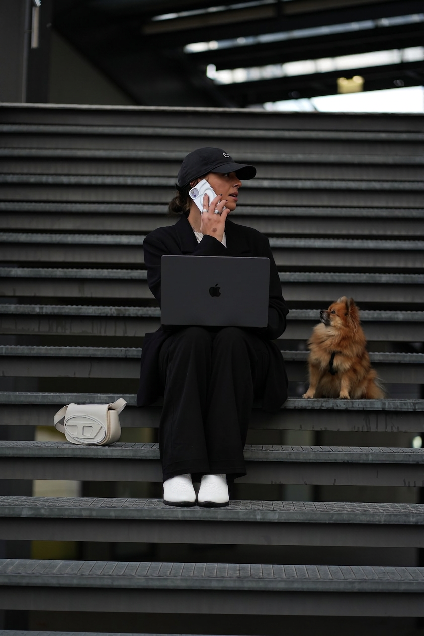 Johanna Ida Kropshofer auf Treppenstufen mit Laptop und Hund